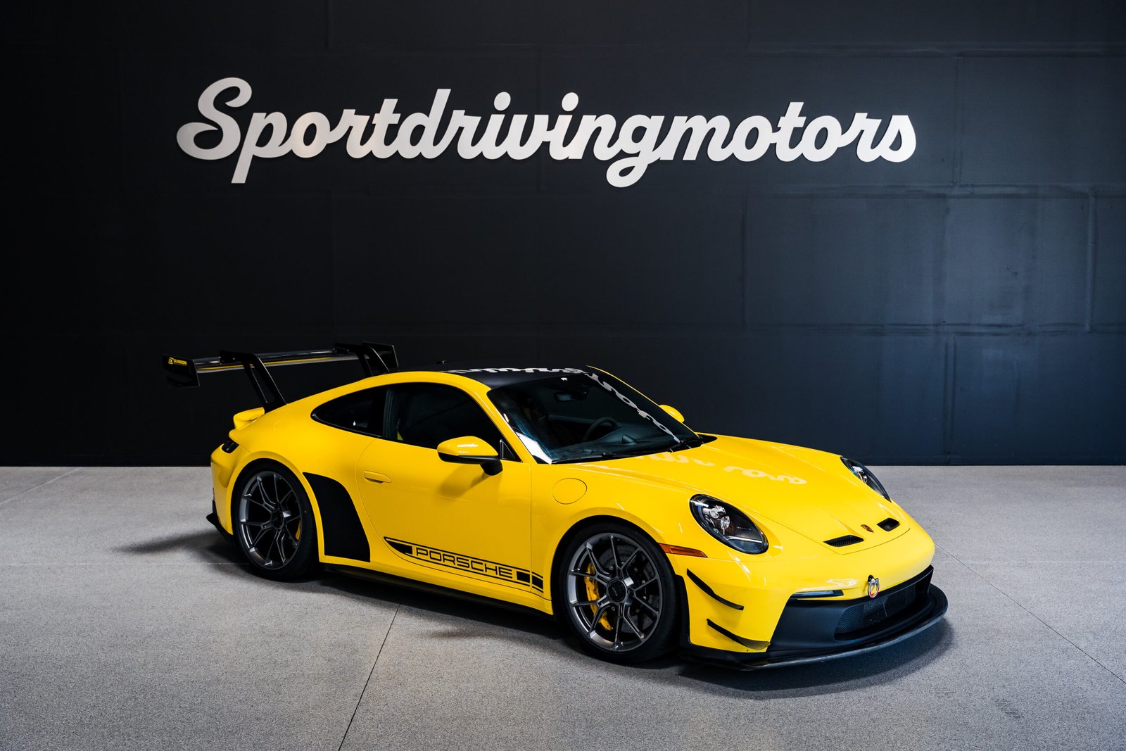 Yellow Porsche 911 side profile in showroom